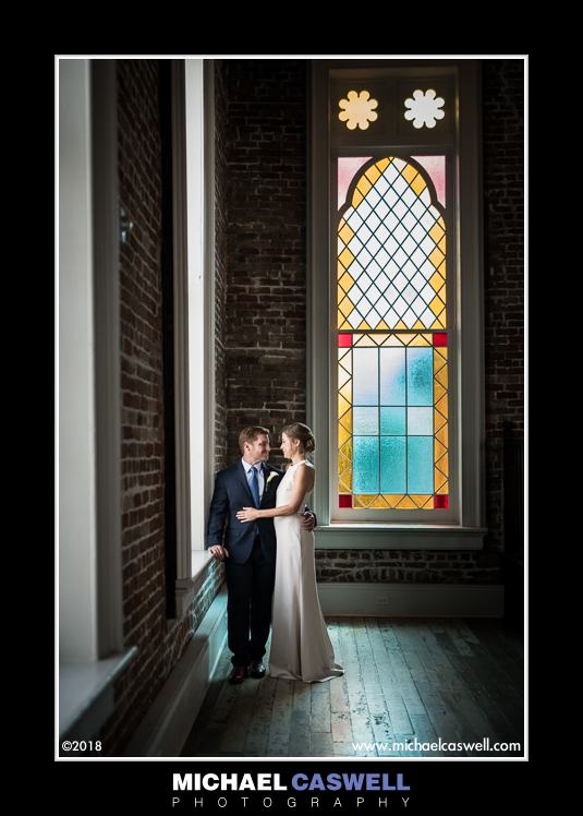 Bride and groom by stained glass window at Felicity Church
