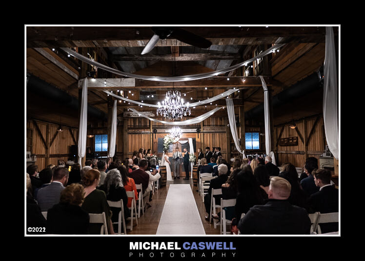 Wide-angle photograph of wedding ceremony in barn
