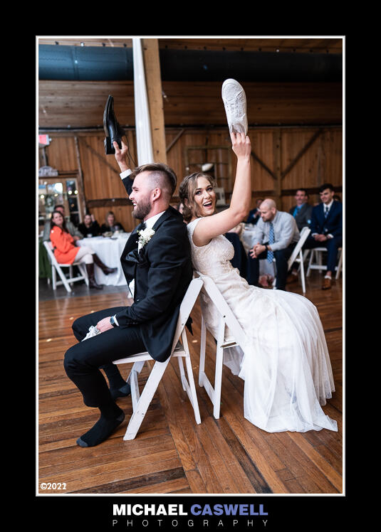 Bride and groom raising shoes during game